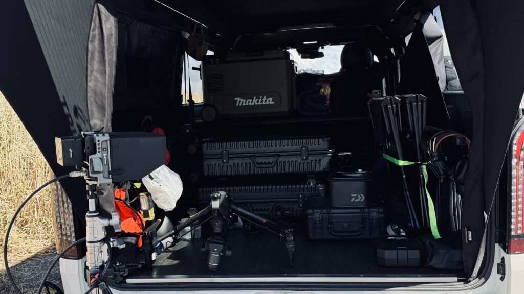 機材車にドローン機材を搭載して撮影現場でセッティングしている様子